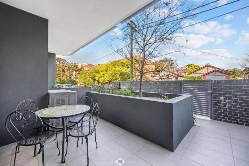 a patio with a table and chairs and a window at Comfy 3 bed near DFO Sydney Olympic Park in Sydney