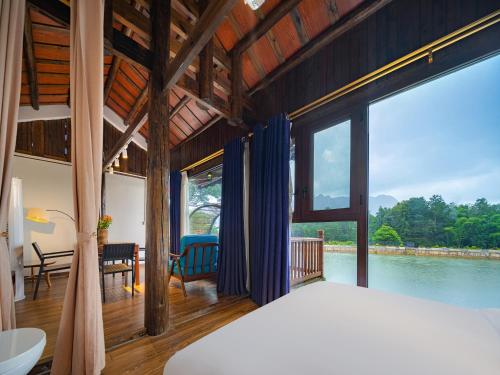 a bedroom with a view of the water at Zhangjiajie Ldyllic Pondside Timber Lodge in Zhangjiajie