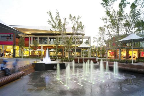 a fountain in front of a shopping center with a building at Modern 4 Bedroom House in Box Hill in Riverstone