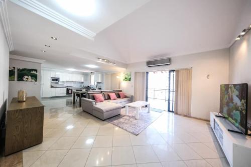 a living room with a couch and a table at Two Level 3 Bedroom Penthouse in Sydney Liverpool in Liverpool