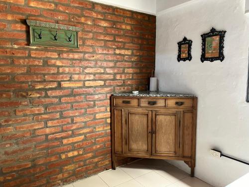 un muro di mattoni con un mobiletto di legno in una stanza di La Floridita a Puerto Pirámides