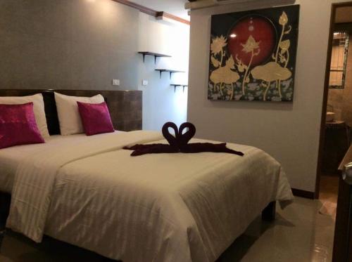 a bedroom with a bed with a ribbon on it at TR Guesthouse in Sukhothai