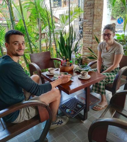 a man and a woman sitting at a table at TR Guesthouse in Sukhothai