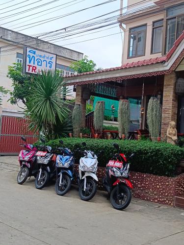 a row of motorcycles parked in front of a store at TR Guesthouse in Sukhothai