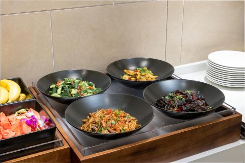 a buffet with four bowls of food on a table at Atour Hotel Shenzhen Futian CBD Gangxia North Metro Station in Shenzhen