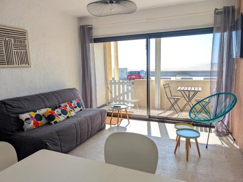 d'un salon avec un canapé et un balcon. dans l'établissement Appartement T2 Front de Mer avec Balcon et Parking – Confort et Activités à Proximité - FR-1-797-37, à Port-la-Nouvelle