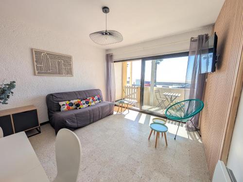 un salon avec un canapé et une table dans l'établissement Appartement T2 Front de Mer avec Balcon et Parking – Confort et Activités à Proximité - FR-1-797-37, à Port-la-Nouvelle