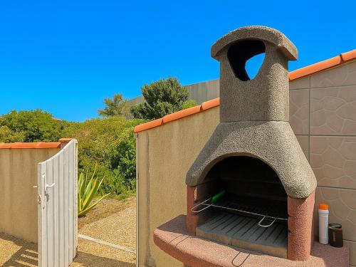 un four à pizza installé sur le côté du bâtiment dans l'établissement Maison en bord de plage avec parking et 2 chambres | Torreilles - FR-1-732-79, à Torreilles