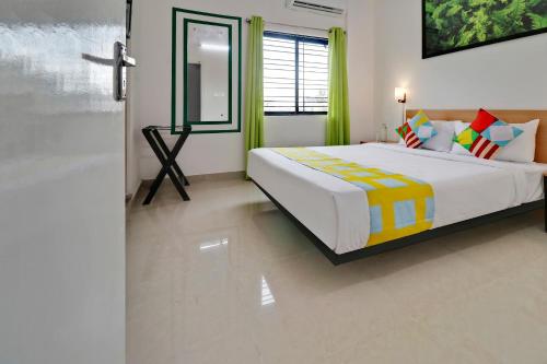a bedroom with a large bed and a window at Hotel O Leva Homes Near Baiyappanahalli Metro Station in Bengaluru