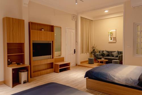 Un dormitorio con una cama, un televisor y un sofá. en Apart Hotel Modern - Hanoi Old Quarter - Netflix - Elevator, en Hanói