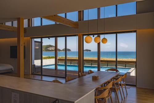 a dining room with a table and a view of the ocean at SETO CLAS TSUDA THE BEACH RESORT A in Yoshimi