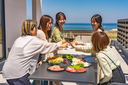 a group of women standing around a table with glasses of wine at SETO CLAS TSUDA THE BEACH RESORT A in Yoshimi