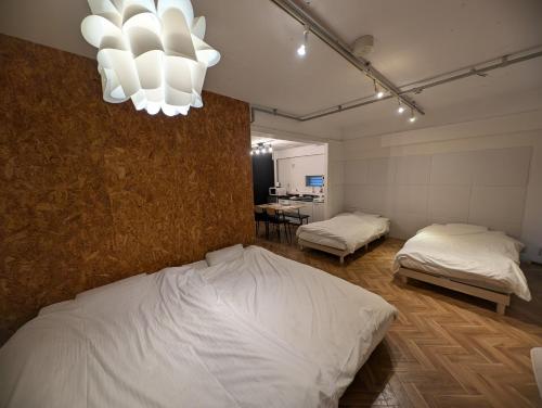 a bedroom with two beds and a chandelier at VIVA Apartment Yabacho in Nagoya