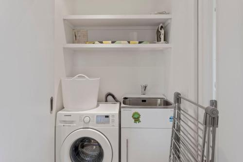 a laundry room with a washing machine and a sink at Dragonflys Rest in Kinloch