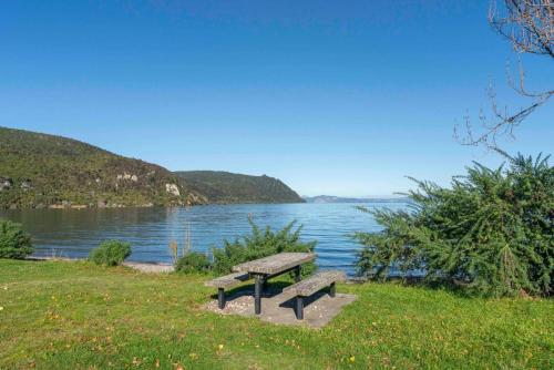 a bench sitting next to a body of water at Dragonflys Rest in Kinloch