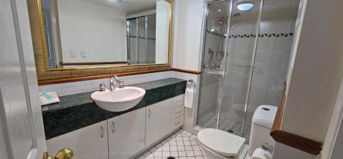 a bathroom with a sink and a shower and a toilet at Broadbeach Holiday Apartments in Gold Coast