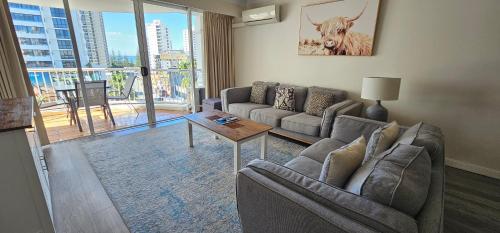 a living room with a couch and a table at Broadbeach Holiday Apartments in Gold Coast