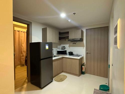 a kitchen with a black refrigerator and a stove at 2 Bedroom Family Suite with Balcony in Lapu Lapu City