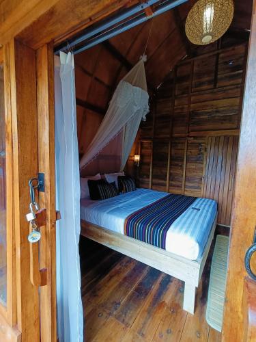 a bed in a room with a mosquito net at Raturinjani homestay in Selong