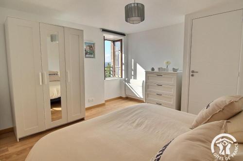 a bedroom with a bed and a dresser with a mirror at La vie est belle in Ploubazlanec