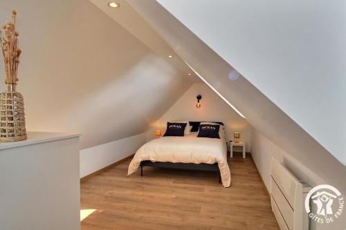 a bedroom with a bed with black pillows on it at La vie est belle in Ploubazlanec