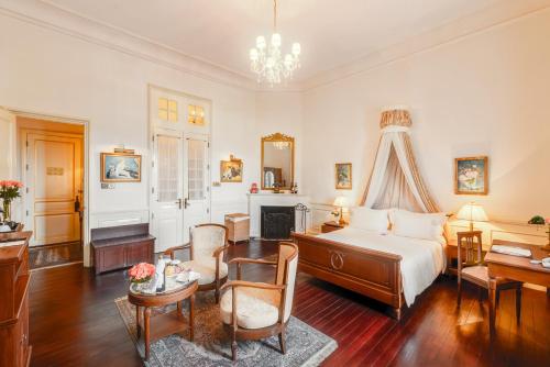 a bedroom with a bed and a desk and a fireplace at Dalat Palace Heritage Hotel in Da Lat
