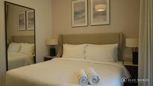 a hotel room with a bed with towels on it at Address Beach Resort Fujairah Apartment by Blue World - 1 in Fujairah