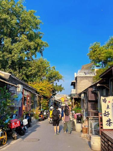 a group of people walking down a street at Beijing city center - Courtyard house hotel located in an ancient Hutong, near the Forbidden City,experience the lifestyle of old Beijing in the exquisite Chinese-style courtyard in Beijing