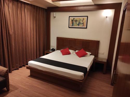 a bedroom with a large bed with red pillows at Hotel Broadway in Chandīgarh