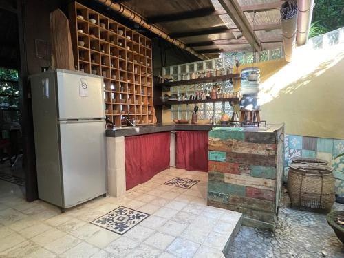 a kitchen with a refrigerator and a counter at Heliconia, at T house kaja in Ubud