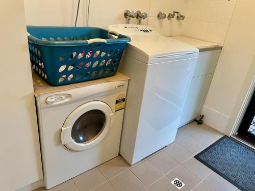 a washing machine and a washer in a bathroom at Owl House on the Corner in Kingscote
