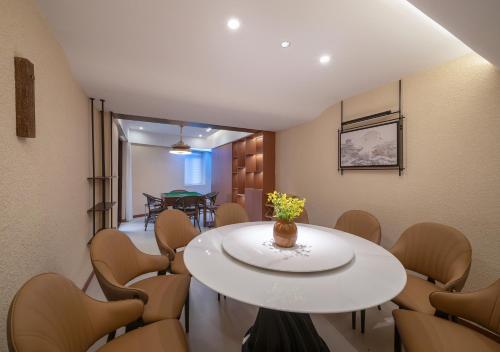 a meeting room with a white table and chairs at Zhangjiajie Ldyllic Pondside Timber Lodge in Zhangjiajie