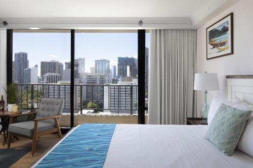 a bedroom with a bed and a view of a city at Refreshing Royal Garden Studio condo in Honolulu