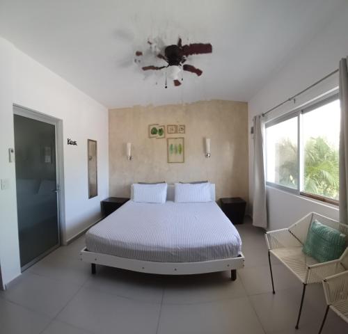 a bedroom with a bed and a ceiling fan at Casa Linda Isla-Room Palmera-Shared Pool in Isla Mujeres