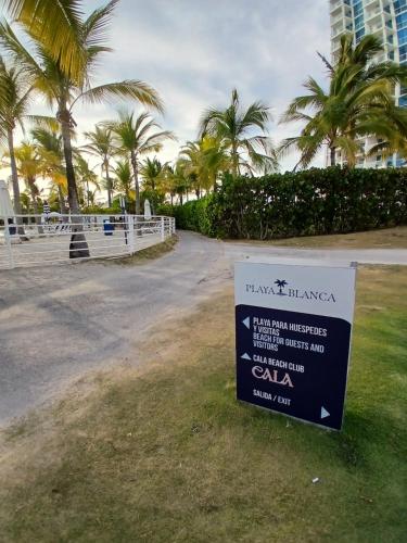 a sign in front of a building with palm trees at Escapada de Lujo frente al Mar in Río Hato