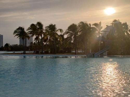 a swimming pool with palm trees and a slide at Escapada de Lujo frente al Mar in Río Hato