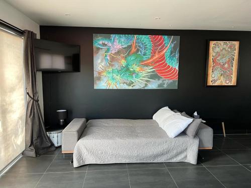 a bedroom with a bed and a painting on the wall at Easy Peasy Open-plan Studio in Hanmer Springs