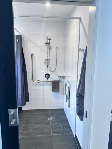 a bathroom with a shower and a tiled floor at Easy Peasy Open-plan Studio in Hanmer Springs