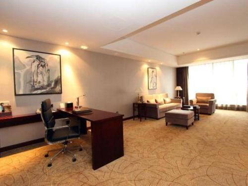a living room with a desk and a couch at Wuhan Soluxe Hotel in Wuhan
