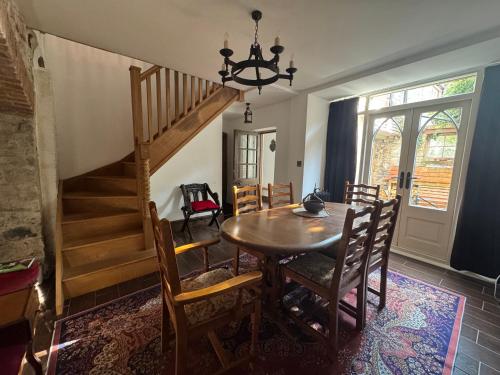 a dining room with a table and chairs and a staircase at Seven Sisters, Glastonbury in Glastonbury