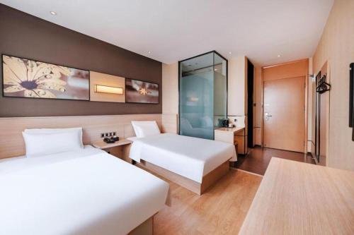 a hotel room with two beds and a bathroom at IU Hotel Kunming Jinma Bijifang Joy City in Kunming