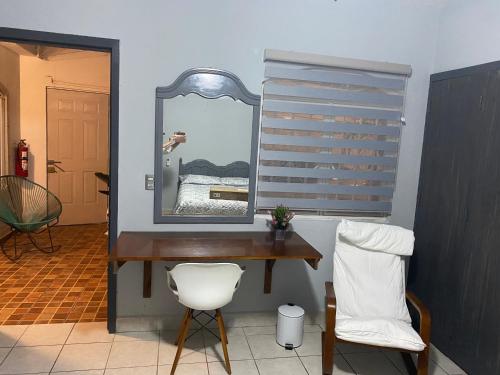 トゥストラ・グティエレスにあるVictoria Habitación Privadaのデスク(鏡付)、椅子が備わります。