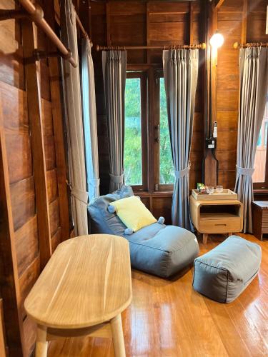 a living room with a bean bag chair and a table at Bann Rai I Na in Phrae