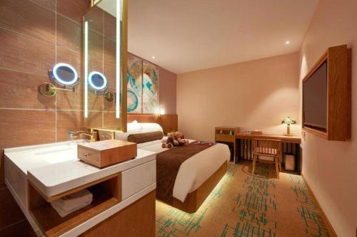 a hotel room with a bed and a sink and a mirror at James Joyce Coffetel Beijing Tongzhou Guoyuan Metro Station in Beijing