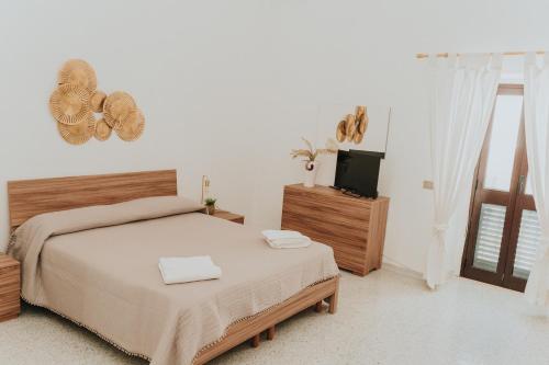 ein Schlafzimmer mit einem Bett und einem Fernseher in der Unterkunft La casa di Cò trilocale Centro storico Gallipoli in Gallipoli