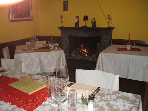 a dining room with two tables and a fireplace at Albergo Michieletto in Valmorea