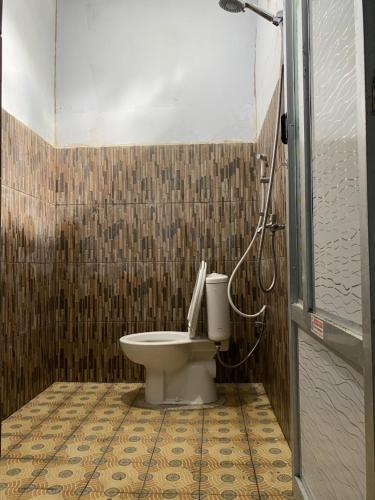 a bathroom with a toilet and a shower at Andre Homestay in Kuta Lombok