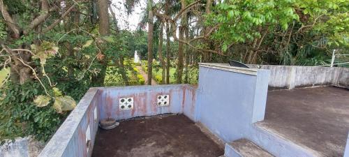 an outdoor area with a concrete wall and trees at Nature villa in Yelagiri