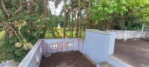 an outdoor area with a concrete wall and trees at Nature villa in Yelagiri