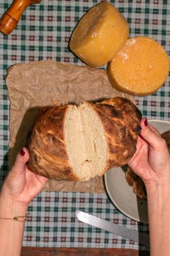 a person holding a loaf of bread on a table at La casa Gallega in Peribeca